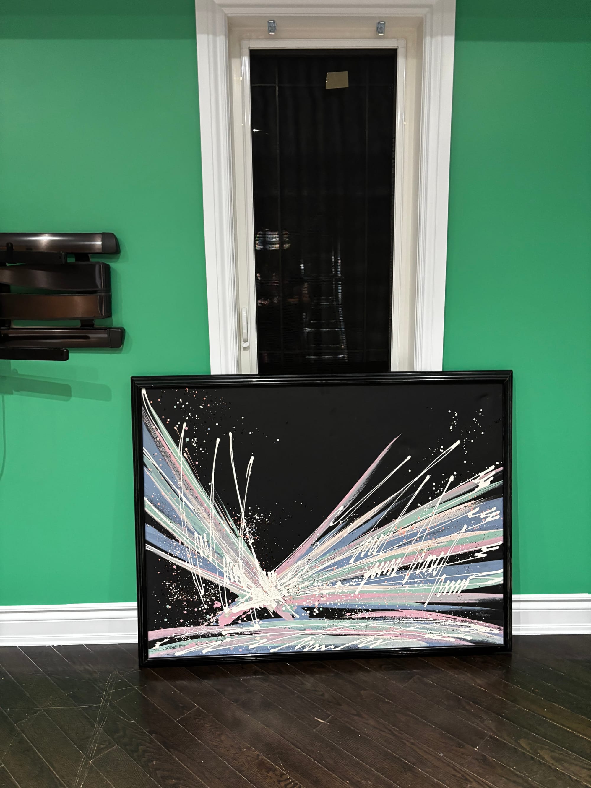 a bright green wall with a large painting in front of it, black with splashes of paint in a pale purple, pink, and white. very vaporwave.