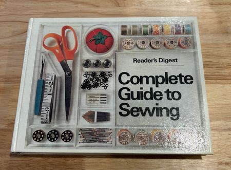 the vintage cover of Readers Digest Complete Guide to Sewing, showing faded photos of sewing tools