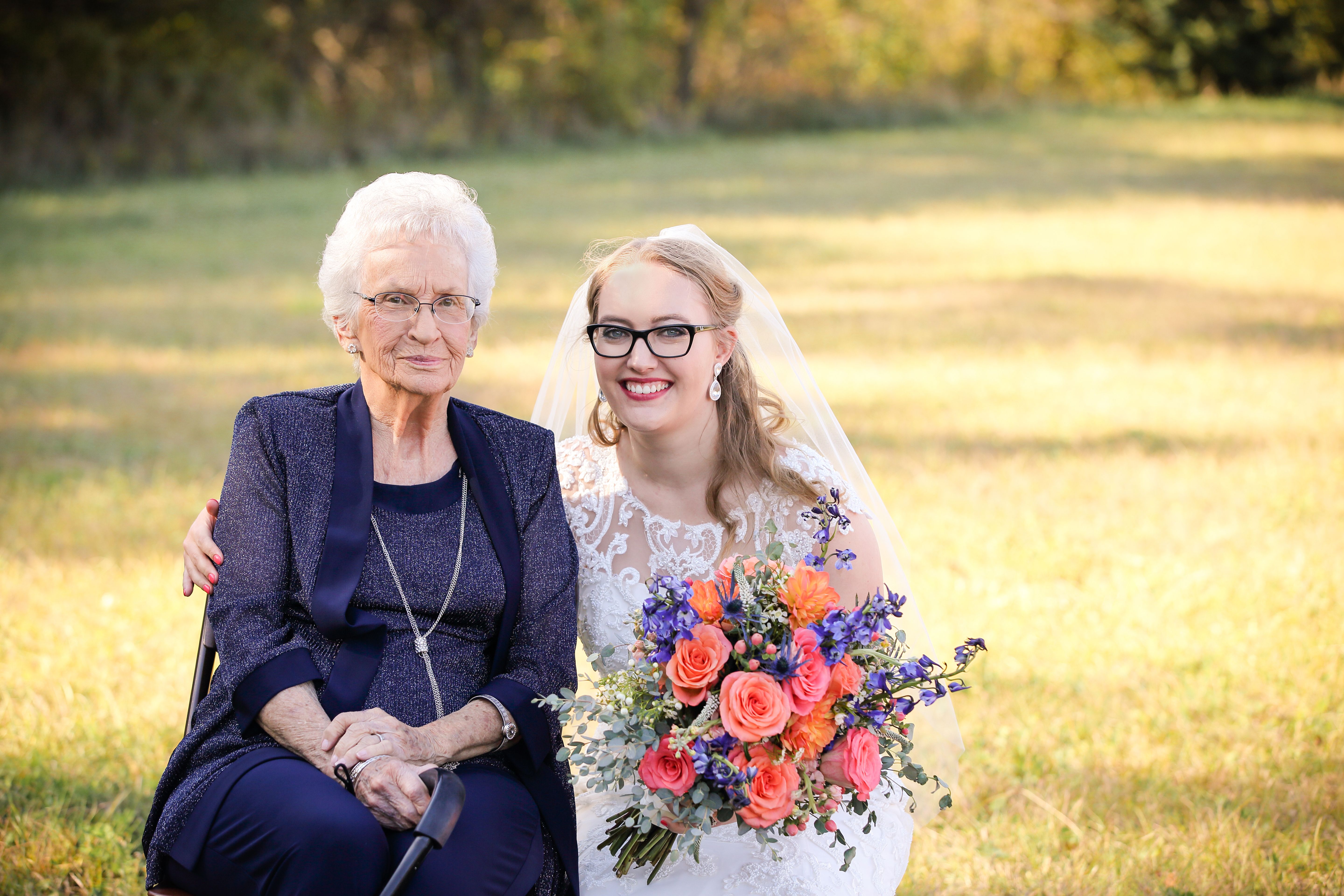 Cassey, in a wedding dress, embraces a well-dressed elderly woman